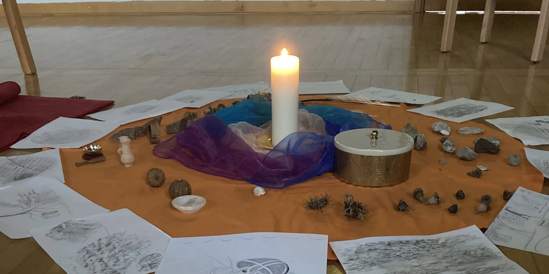 Ruhiger Meditationsraum mit Kerze, Kristallen und spirituellen Gegenständen im Benediktinerabtei Michaelbeuern.